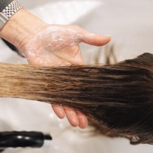 Close-up of a professional hair wash in a salon setting, highlighting hand technique.